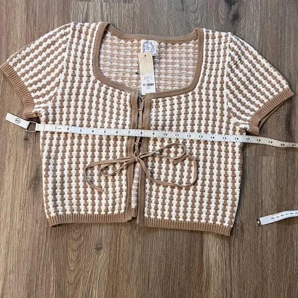 Francesca’s 
Medium
Crop Short Sleeve 
Tie front sweater
Tan/white
Herringbone - Picture 6 of 7